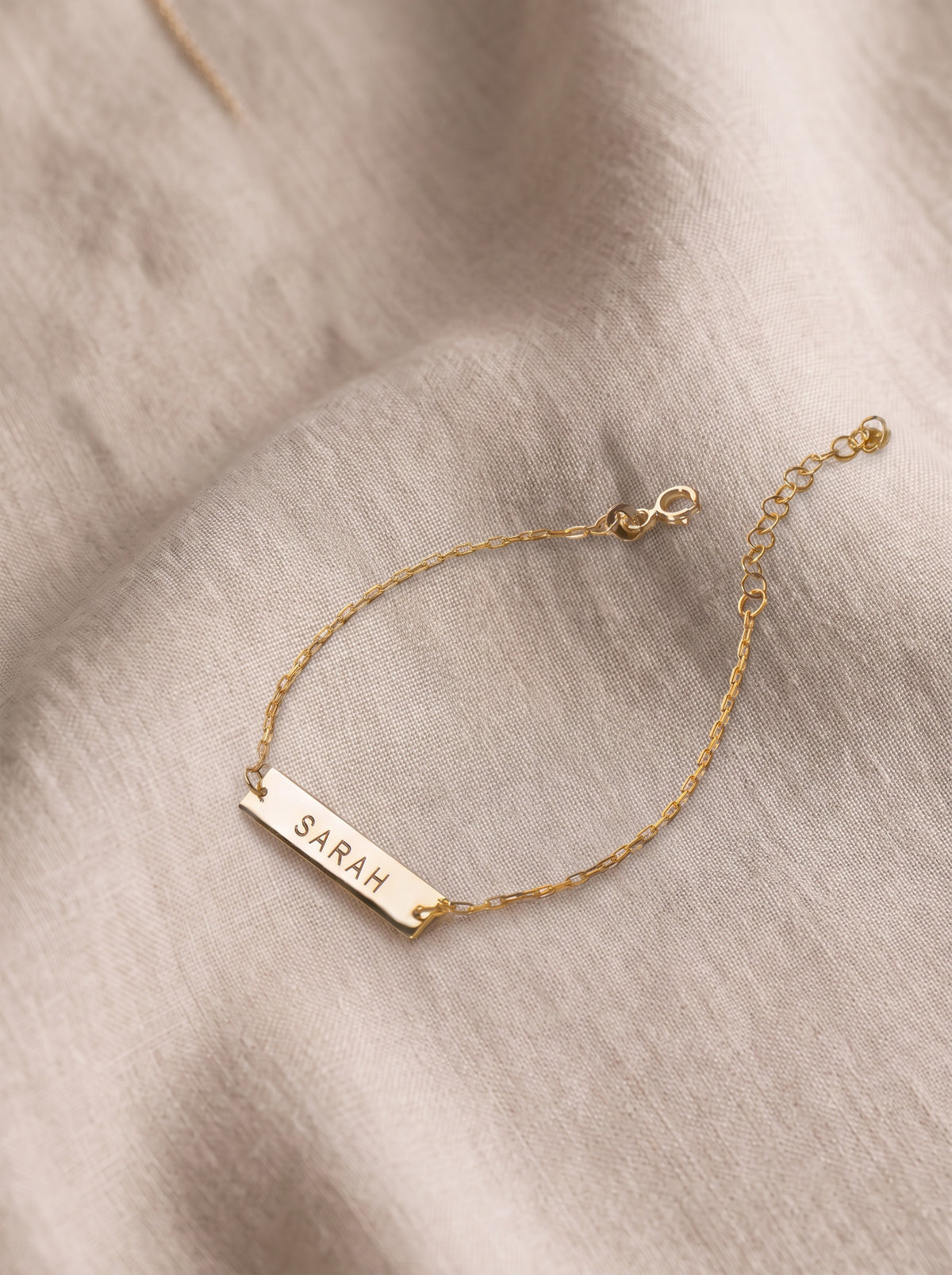 Pulsera con placa de nombre grabada
